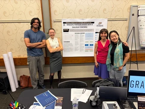 Presenters beside a research poster at the Purdue AI Research Showcase